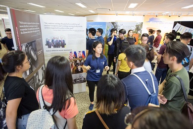 Young people viewing the panels of an exhibition and listening to a guide