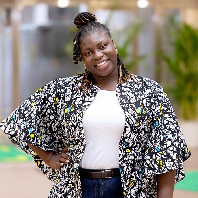 Woman with hand on hip outside.