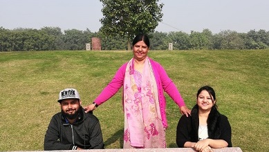 Una mujer posa con dos jóvenes en un parque