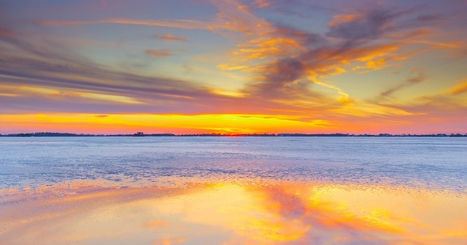 Sunset colors reflecting on the sea and clouds.