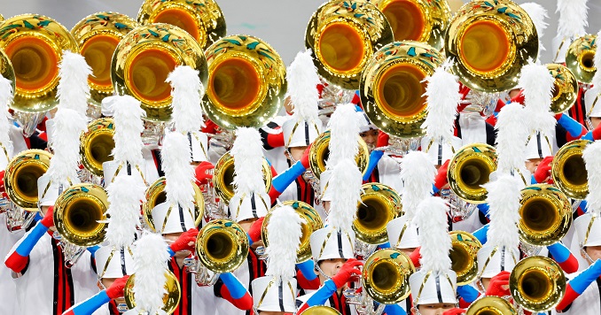 People in white and red uniforms playing shining brass instruments