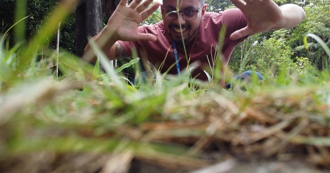 Man looking happy behind some grass