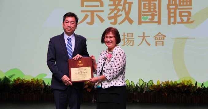 Two people posing with an award