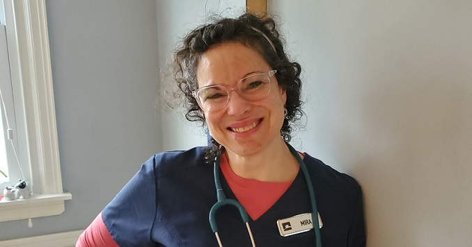 A smiling woman in a nurse’s uniform