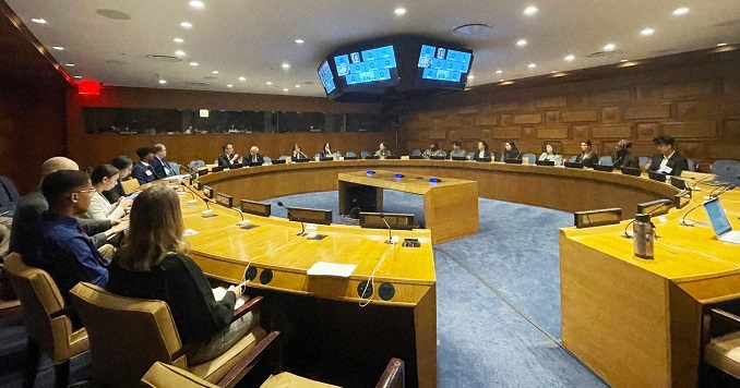 Personas sentadas en una mesa redonda en una sala de conferencias