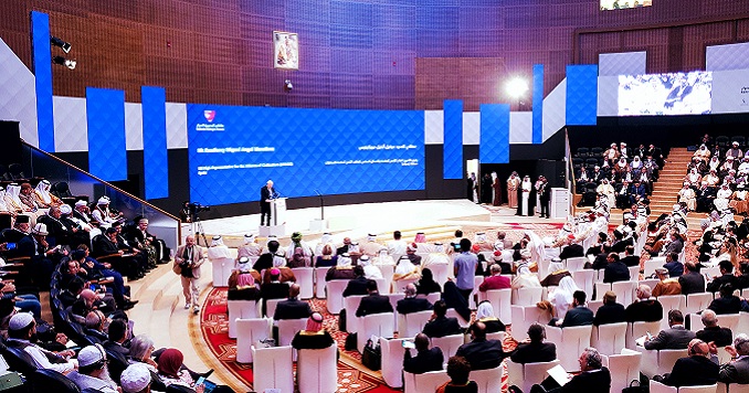 People seated in a grand conference room facing the front stage.