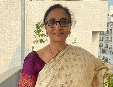 Woman in a sari standing on a balcony.