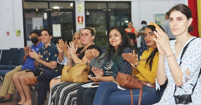 Una fila de personas sentadas aplaudiendo.