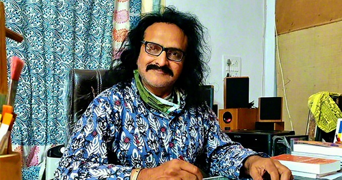 A man sitting behind a desk looking at a camera.