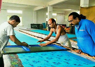 Three men in a textile art studio.