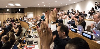 Un grupo de personas aplaude efusivamente en una sala de conferencias 