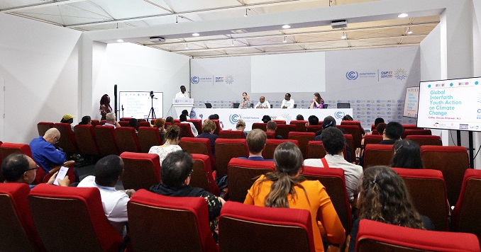 Audience facing a panel of speakers