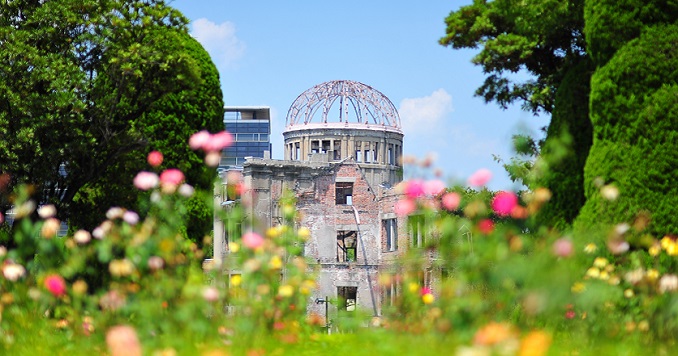 Flores y arbustos verdes frente a la cúpula de Hiroshima