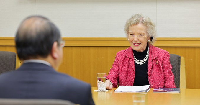 A man and woman seated around a table in conversation.