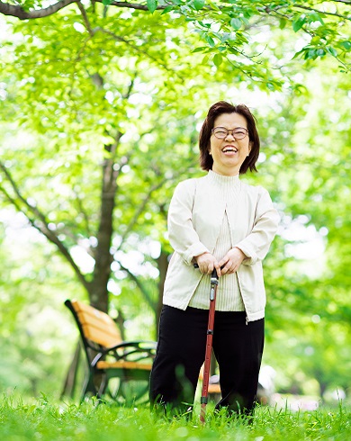 Person standing in a park with a cane