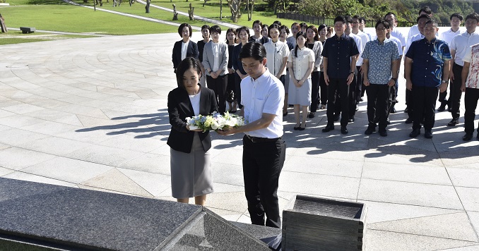 Dos jóvenes depositan una corona de flores ante la Piedra Angular de la Paz.