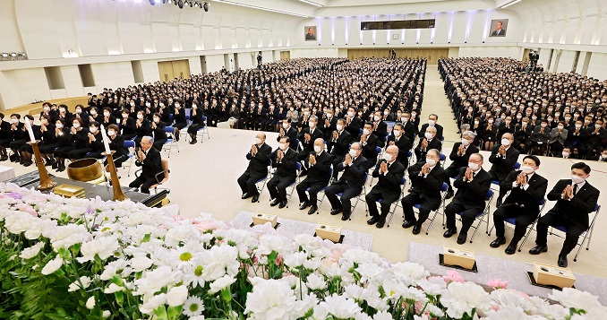 Seated people wearing black in a hall