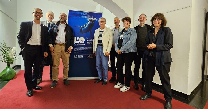 Ocho personas posan para una foto de grupo delante de un panel de la exposición.