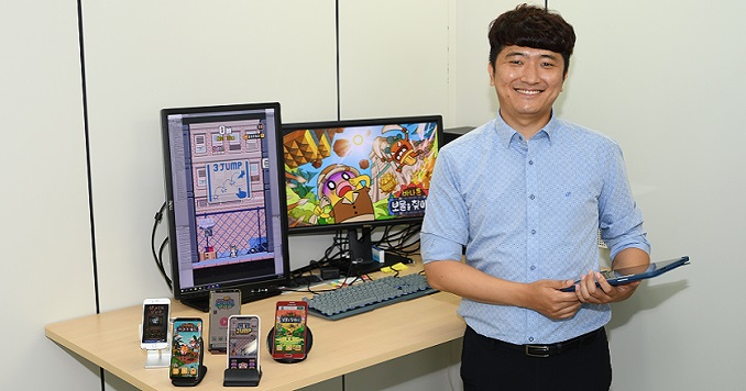 A man standing in front of his desk facing the camera.