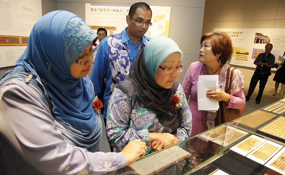 Mujeres musulmanas contemplan los manuscritos del Sutra del loto en una sala de exposiciones