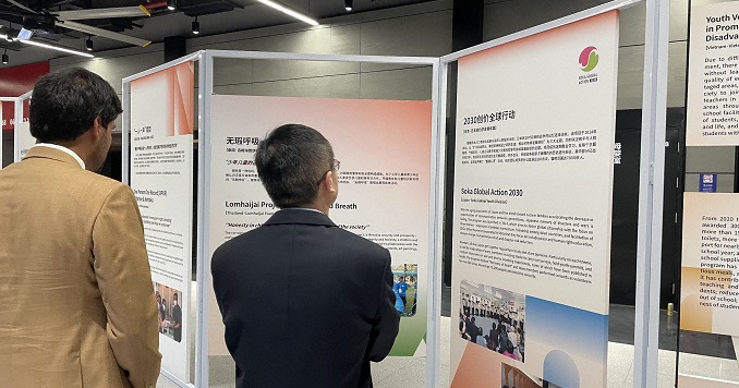 Two men viewing exhibition panels.