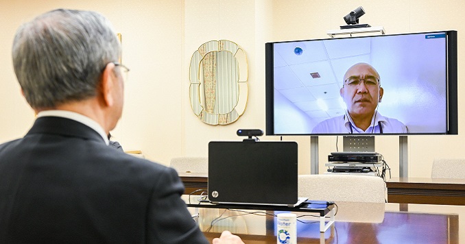 Un hombre mira una pantalla durante una reunión en línea.