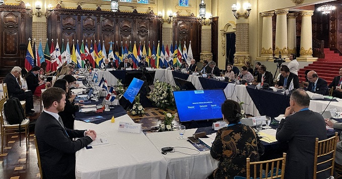 Personas sentadas alrededor de una mesa en una sala de conferencias. 