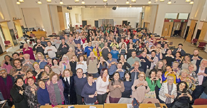 A big group of people in a conference room posing for a commemorative photo.