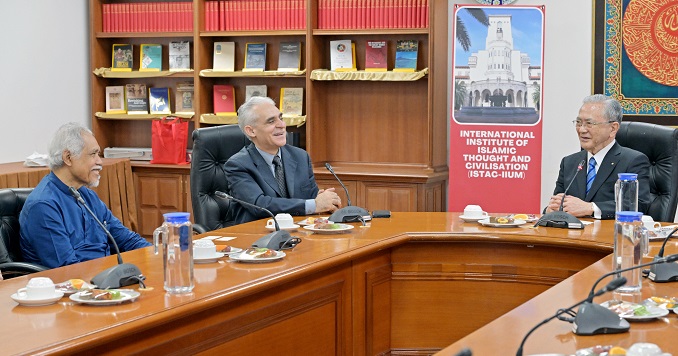 Three people seated at a conference table.