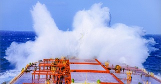 Large wave pounding the front of a ship.