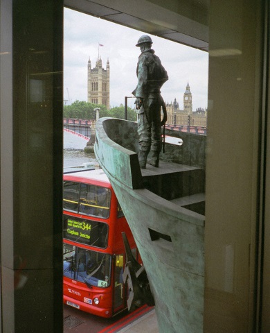 Statue of a seafarer on the bow of a ship with Big Ben and the Palace of Westminster in the background.