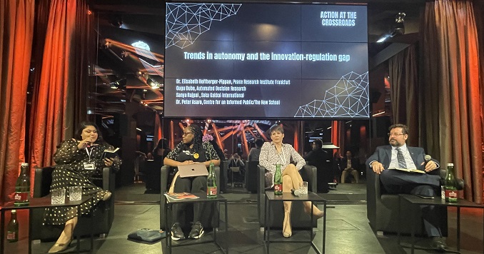 Four people on a stage engaging in a discussion.