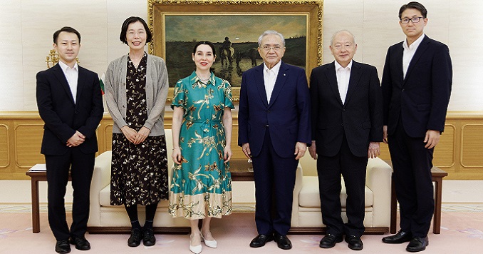 Five people standing in a line for a commemorative photo.