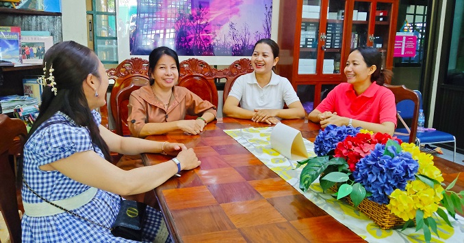 四名女性圍坐在桌前,微笑地看向彼此。