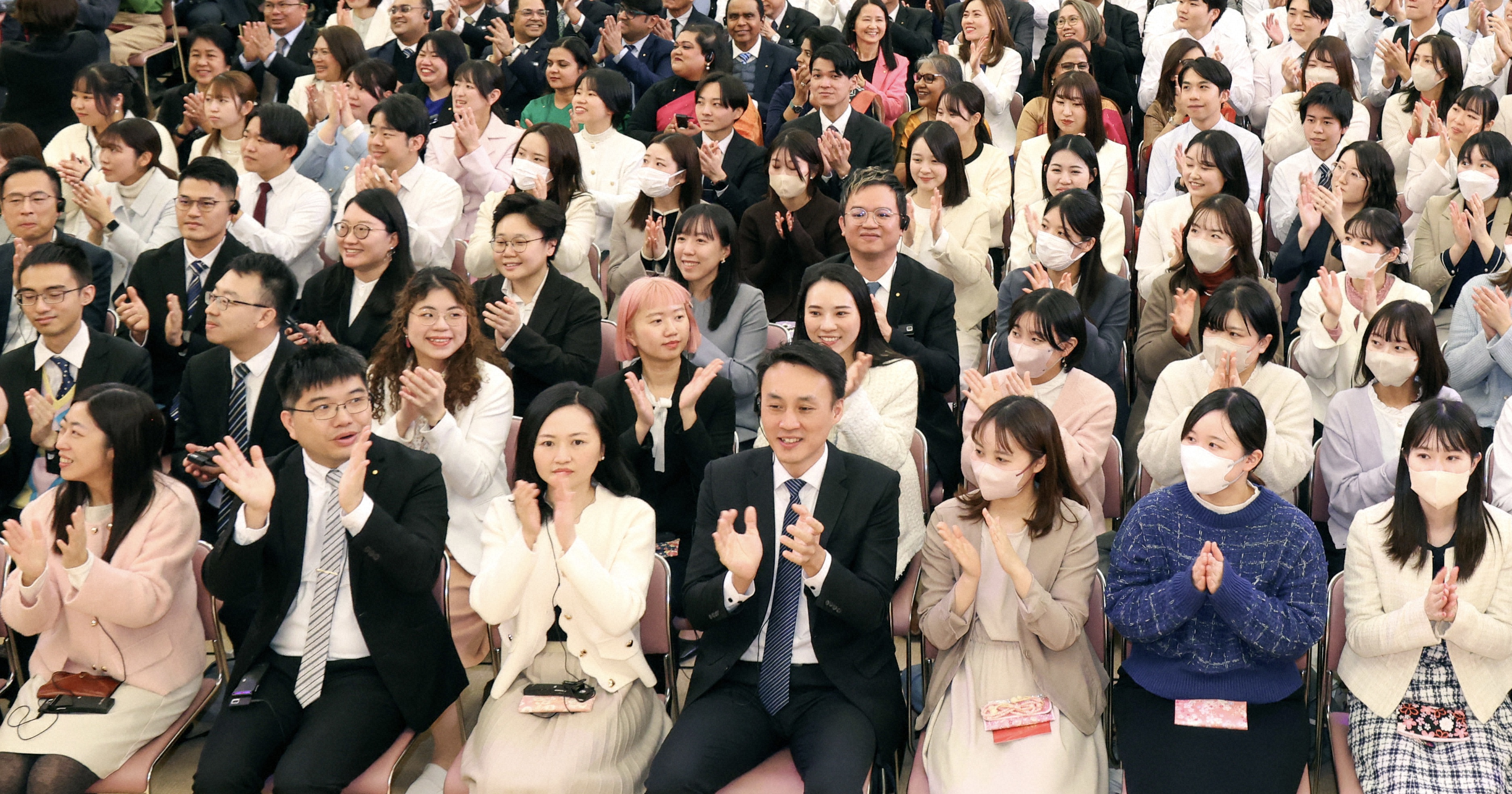 在大講堂裡就坐的人們正在拍手。