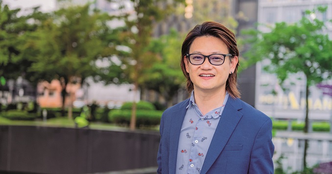 A man with glasses in a suit smiling at the camera.