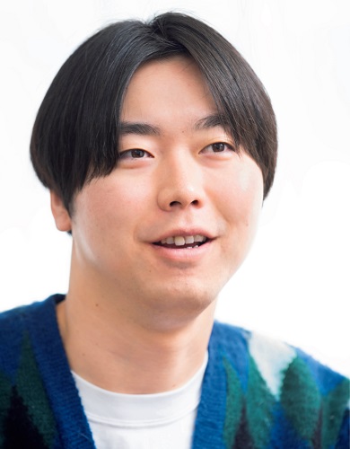 A close-up photo of a man smiling and talking.