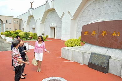 Several women dressed smartly looking at a large marble monument.