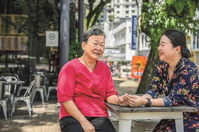 Szi Hean and her mother sitting at a table outside together