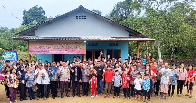 People standing outside a new building for a commemorative photograph.