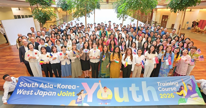 A large group of young people from six countries stand together holding a banner and posing for a commemorative photo.