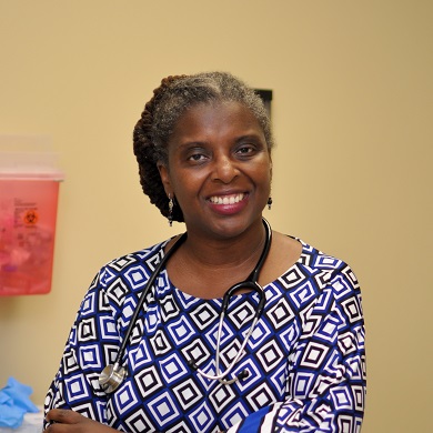 妇人站在室内黄棕色墙面前的特写照片。