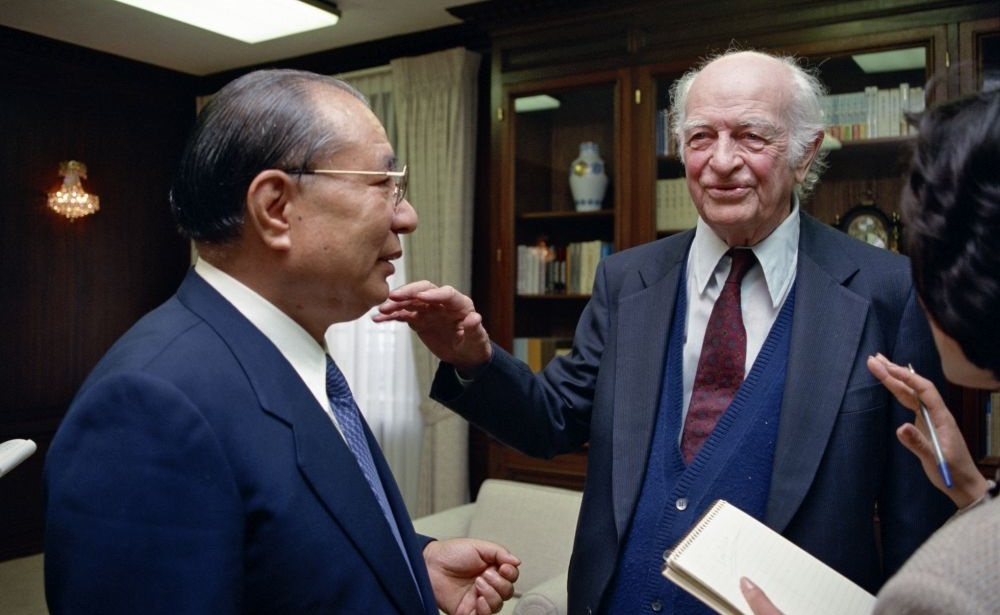 Daisaku Ikeda y Linus Pauling de pie y conversando