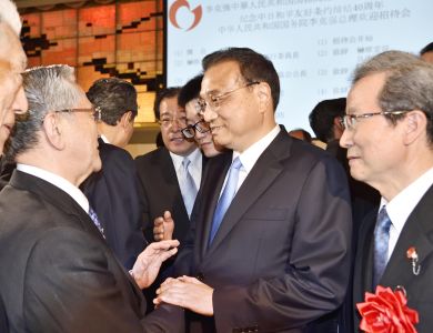 Premier Li and President Harada shaking hands as Chinese Ambassador to Japan H.E. Cheng Yonghua looks on