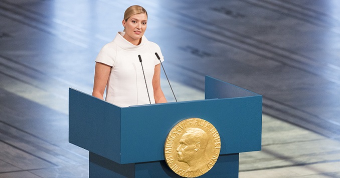 A woman speaking at a large podium