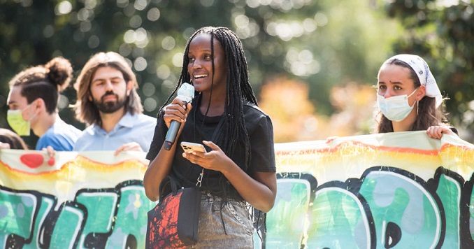 Vanessa Nakate sostiene un micrófono mientras habla en una manifestación