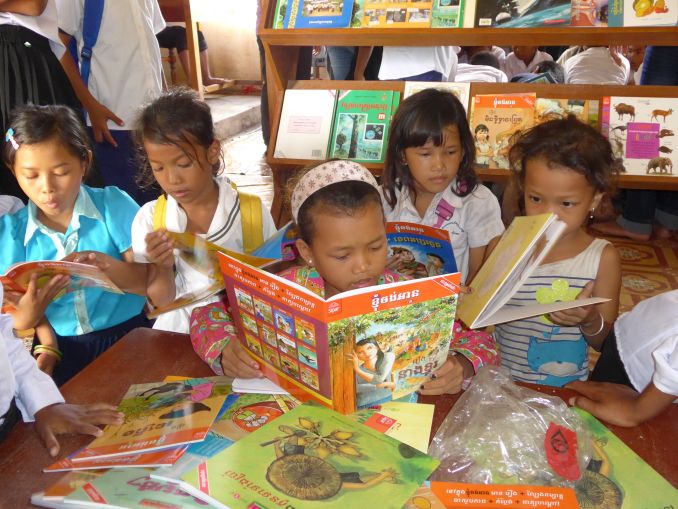 Elementary schoolchildren engrossed in reading the donated books