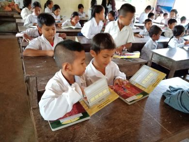 Boys reading the books together in their classroom