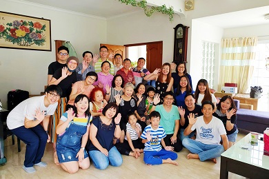 Foto grupal de unos 30 hombres, mujeres y niños sonrientes