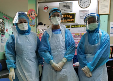 Three people standing in an office in protective medical clothing